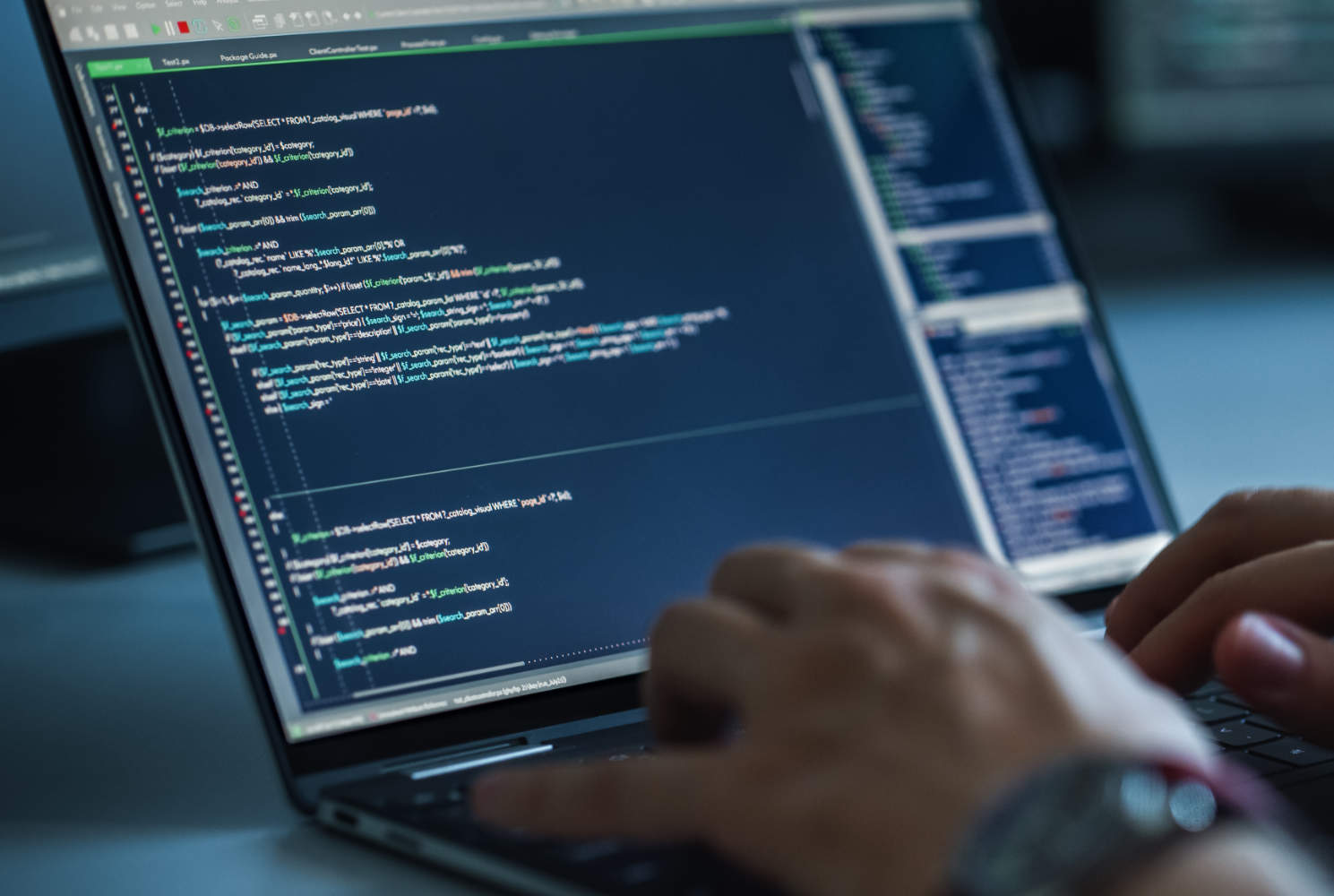 Close-up focus on computer screens showing code on the screen. Programming stock photo